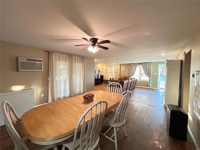 dining area featuring hardwood / wood-style floors, ceiling fan, and an AC wall unit