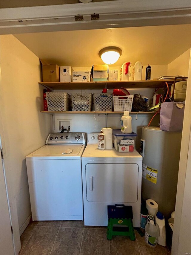 laundry area with electric water heater, dark tile patterned floors, and independent washer and dryer