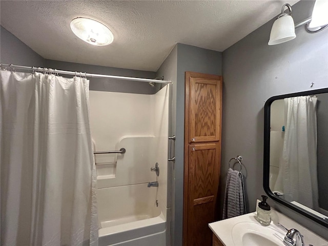 bathroom featuring shower / tub combo with curtain, vanity, and a textured ceiling