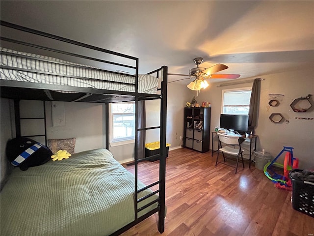 bedroom featuring wood-type flooring, multiple windows, and ceiling fan