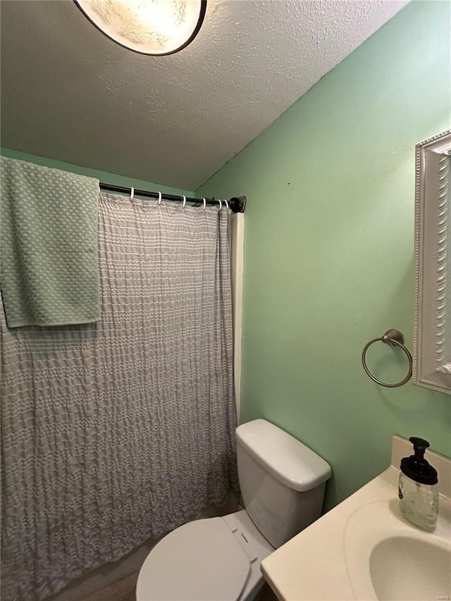 bathroom featuring vanity, a shower with shower curtain, a textured ceiling, and toilet