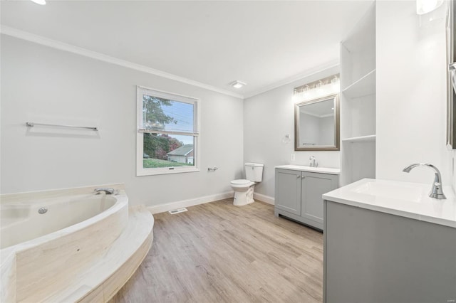 bathroom featuring a tub, crown molding, hardwood / wood-style floors, toilet, and vanity