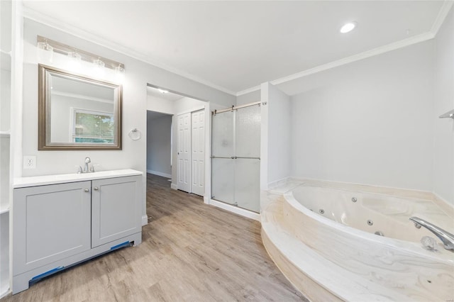 bathroom featuring hardwood / wood-style floors, vanity, ornamental molding, and independent shower and bath