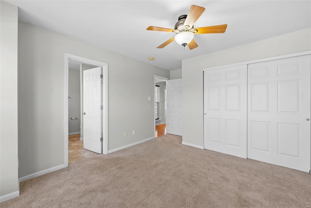 unfurnished bedroom with ceiling fan, light carpet, and a closet