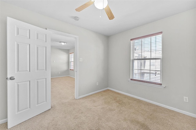 spare room with light colored carpet and ceiling fan