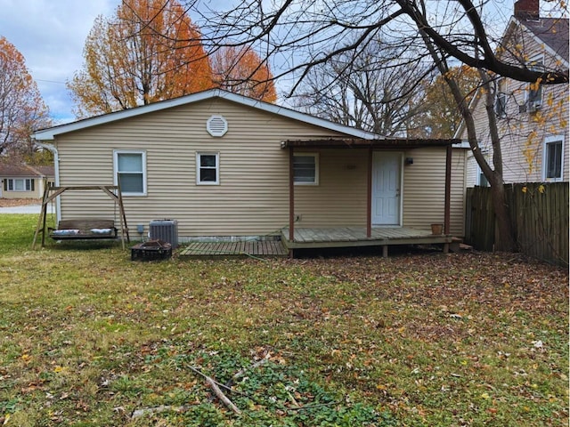 back of house featuring a wooden deck, a yard, central AC unit, and an outdoor fire pit