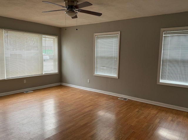 spare room with ceiling fan and light wood-type flooring