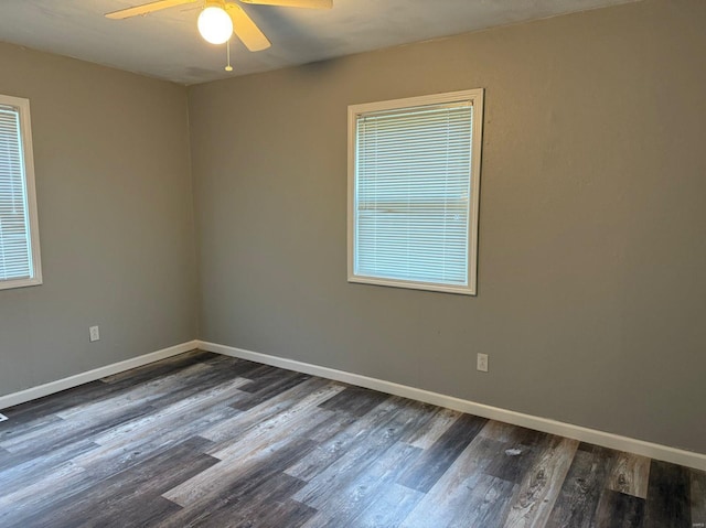 spare room with dark hardwood / wood-style flooring, ceiling fan, and plenty of natural light