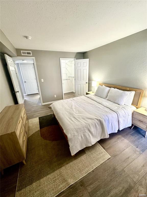 bedroom with dark wood-type flooring and a textured ceiling