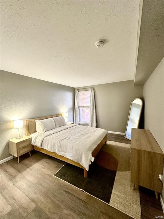 bedroom featuring hardwood / wood-style floors and a textured ceiling