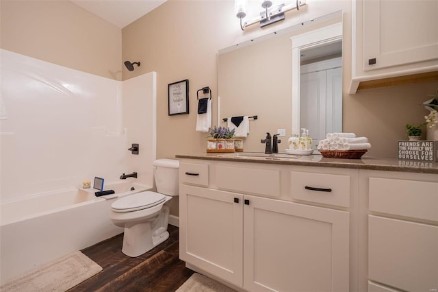 full bathroom with toilet, washtub / shower combination, vanity, and wood-type flooring