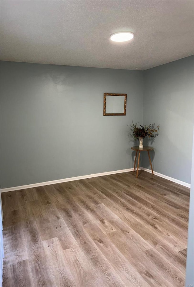 spare room with wood-type flooring and a textured ceiling