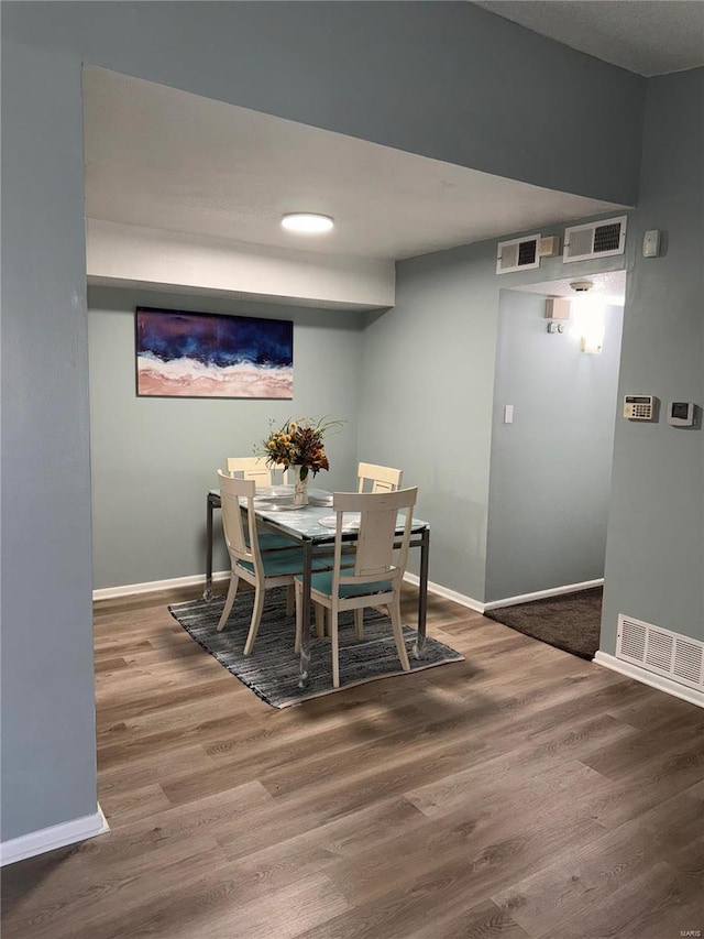 dining space with wood-type flooring