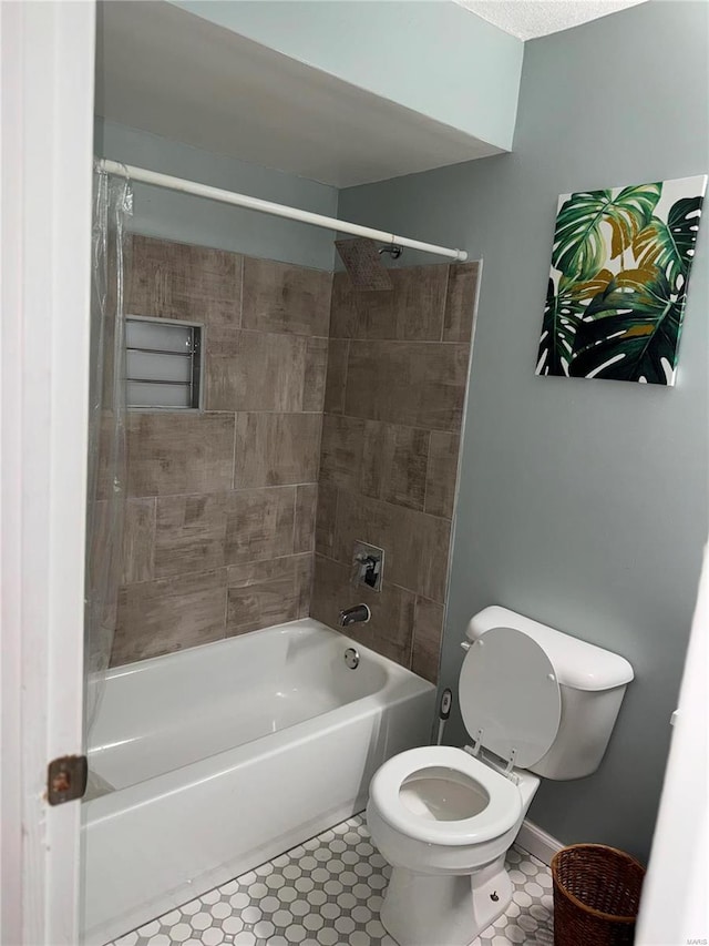 bathroom featuring toilet and tiled shower / bath