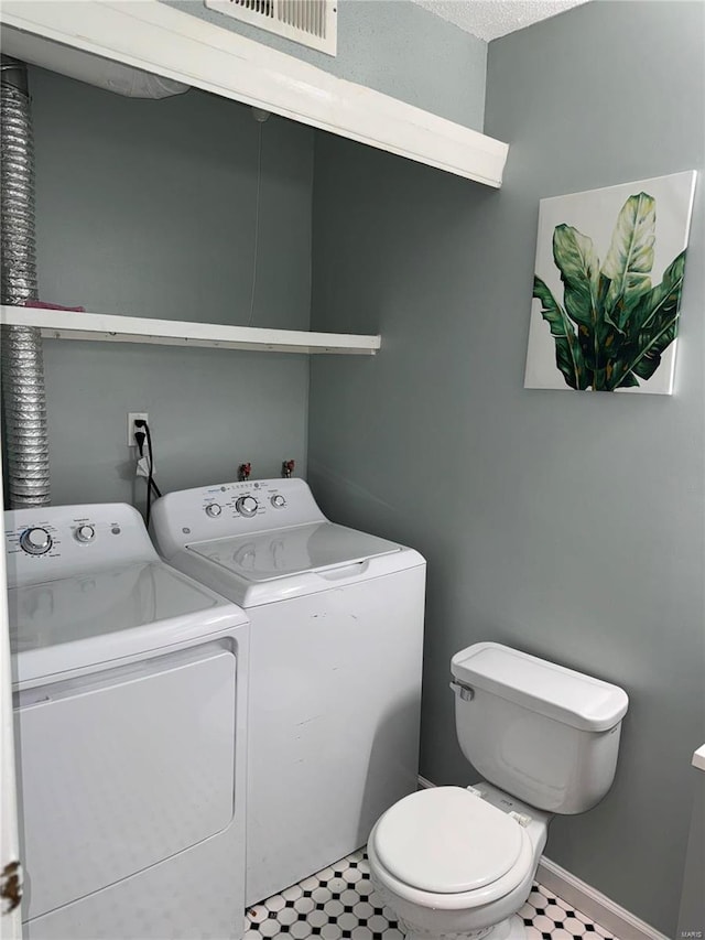 bathroom with washer and clothes dryer and toilet