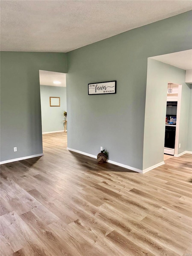 empty room featuring hardwood / wood-style flooring and a textured ceiling