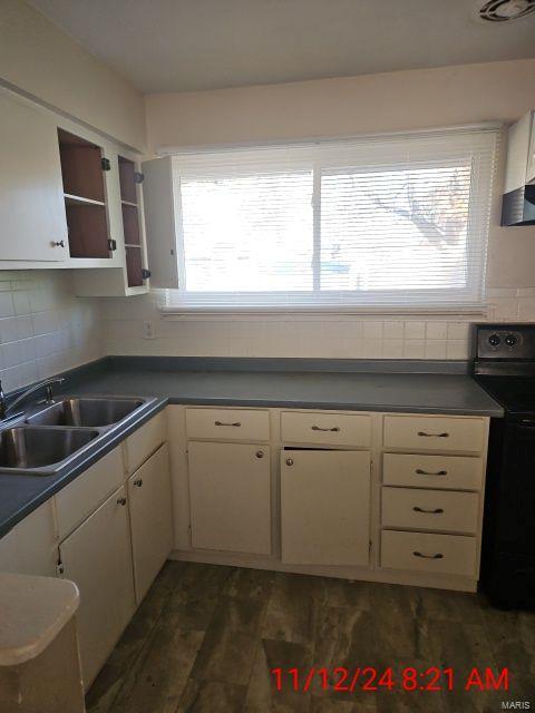 kitchen with open shelves, dark wood-style flooring, a sink, decorative backsplash, and black electric range oven