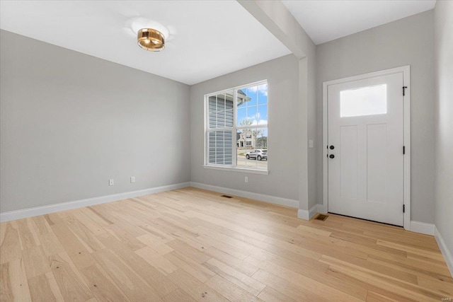 foyer featuring light wood-style flooring and baseboards
