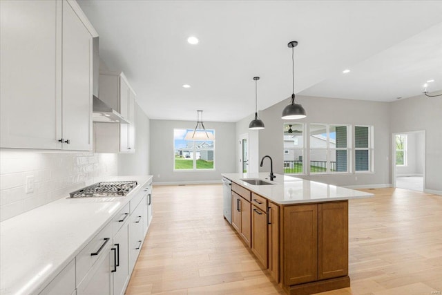 kitchen with open floor plan, light wood-style flooring, stainless steel appliances, and a sink