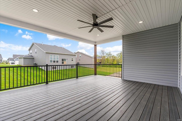 wooden deck featuring a residential view, a lawn, and ceiling fan
