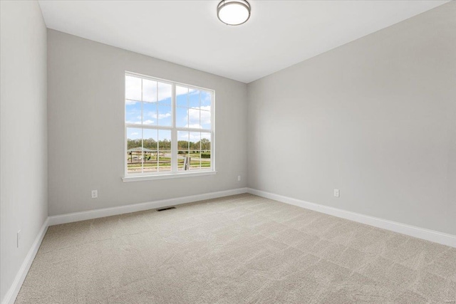 carpeted empty room featuring visible vents and baseboards