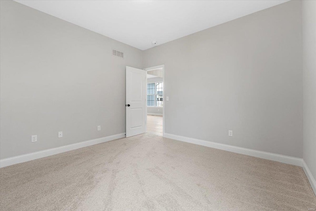 unfurnished room with light carpet, baseboards, and visible vents