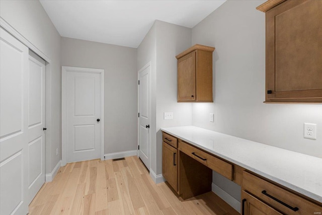 interior space featuring light wood-type flooring and baseboards