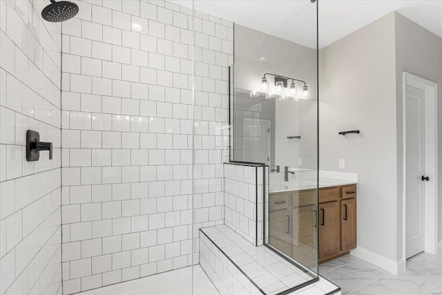 full bath with marble finish floor, baseboards, vanity, and a walk in shower