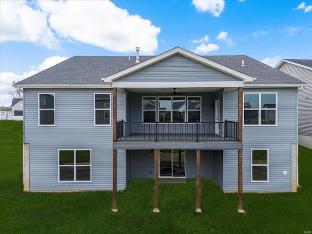 rear view of property with a lawn, a shingled roof, and a balcony