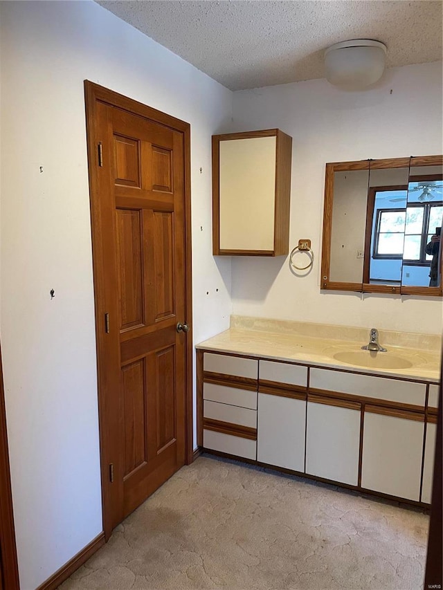 bathroom featuring a textured ceiling and vanity