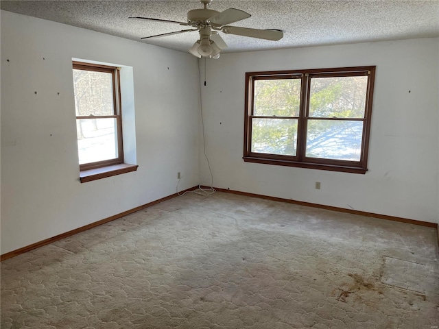 carpeted spare room with ceiling fan and a textured ceiling