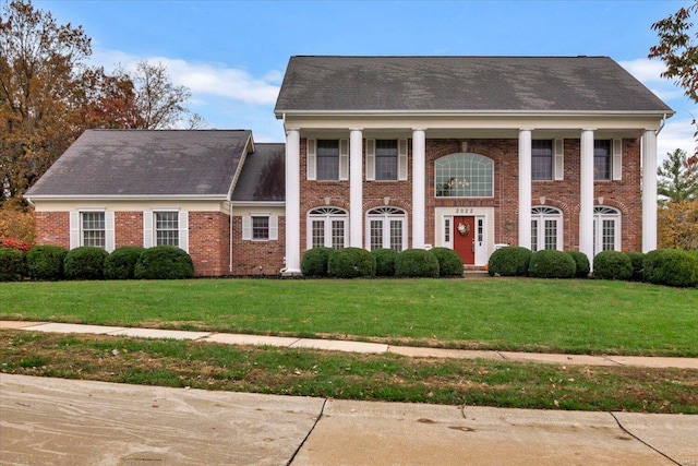 greek revival inspired property featuring a front lawn