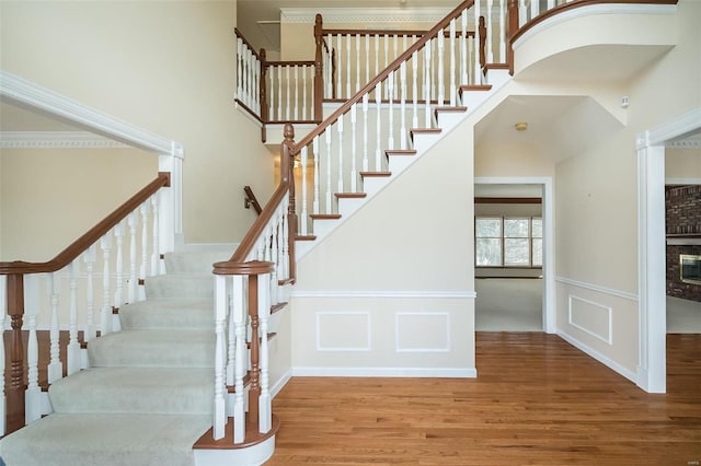 stairway featuring wood-type flooring and a fireplace