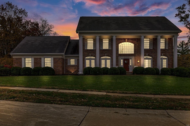 greek revival inspired property featuring a lawn