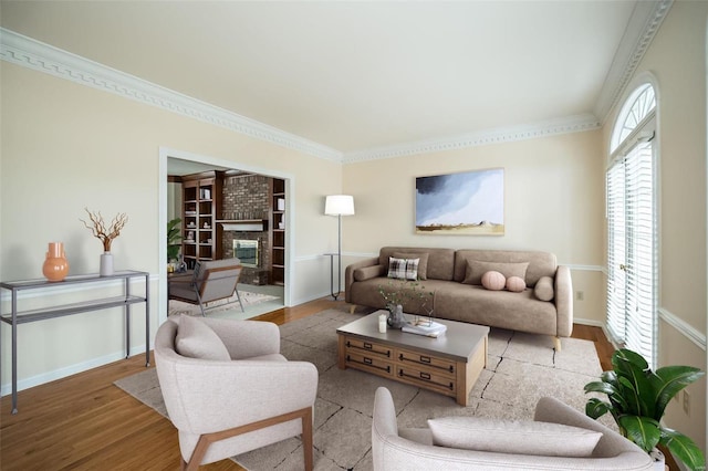 living room with ornamental molding, wood-type flooring, and a brick fireplace