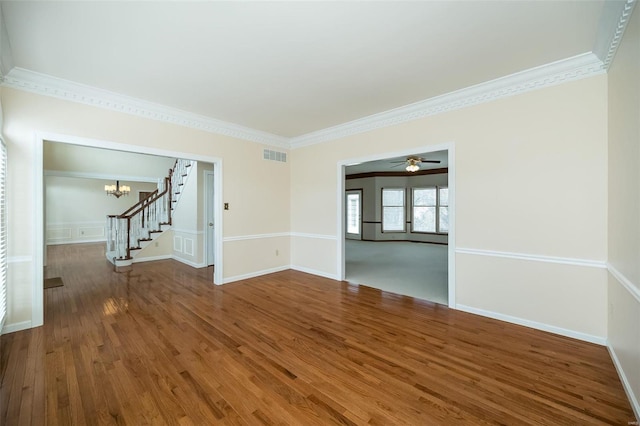 empty room featuring dark hardwood / wood-style flooring, ornamental molding, and a chandelier