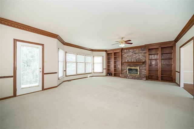 unfurnished living room with built in shelves, a fireplace, carpet floors, and a wealth of natural light