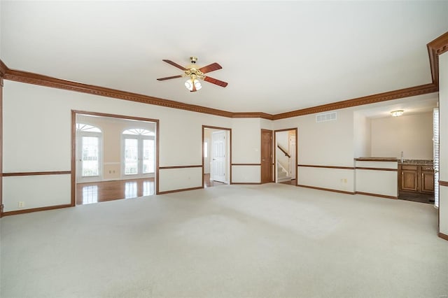 spare room featuring crown molding, light colored carpet, and ceiling fan