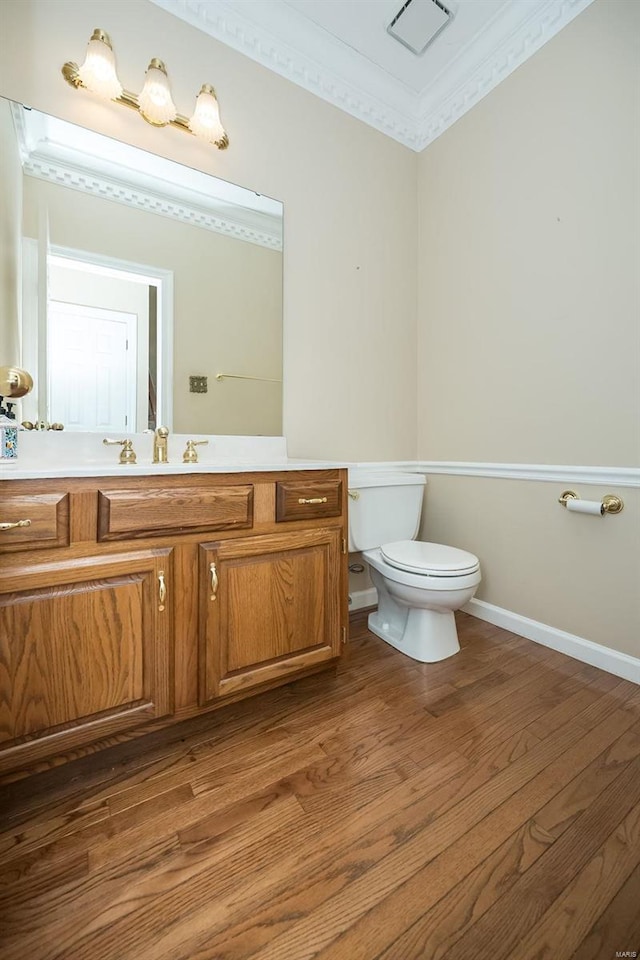 bathroom with vanity, hardwood / wood-style flooring, ornamental molding, and toilet