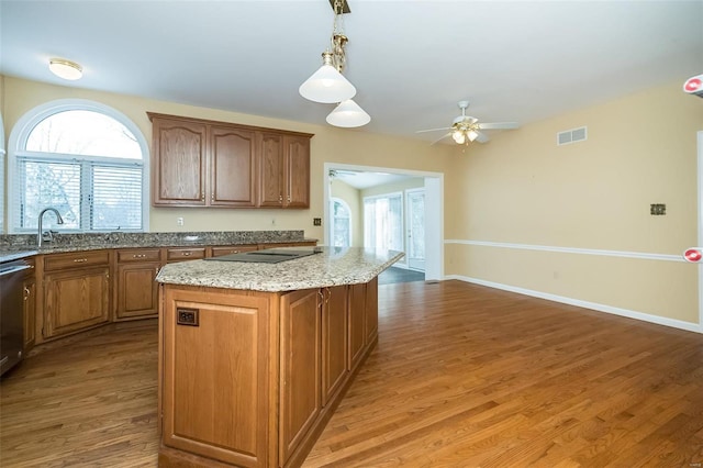 kitchen featuring wood-type flooring, a kitchen island, pendant lighting, and ceiling fan