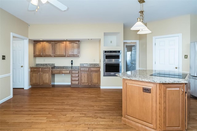 kitchen with hardwood / wood-style floors, decorative light fixtures, a center island, ceiling fan, and stainless steel appliances