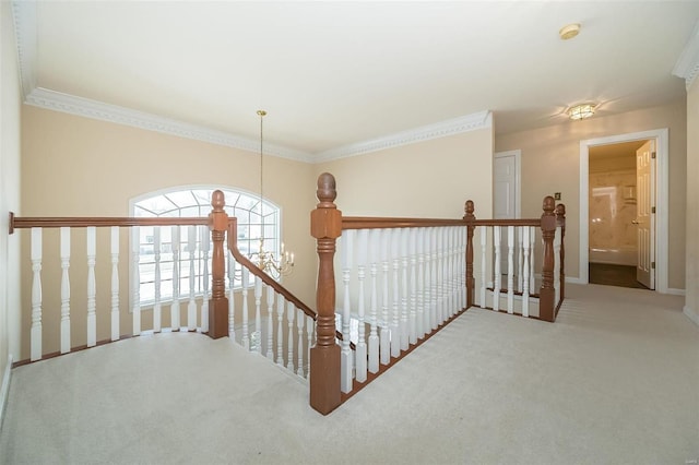 hallway with ornamental molding, carpet, and a notable chandelier