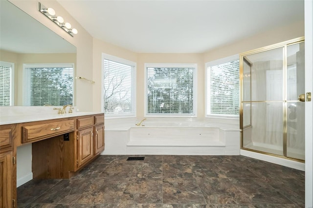 bathroom featuring vanity, a wealth of natural light, and plus walk in shower