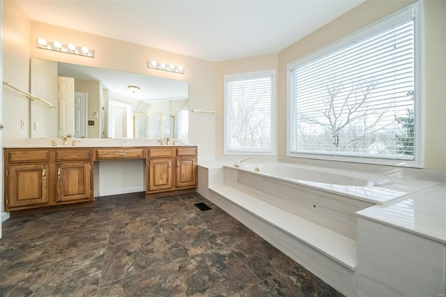 bathroom featuring vanity and a washtub