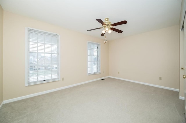 carpeted empty room with plenty of natural light and ceiling fan