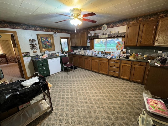 kitchen featuring white dishwasher, ceiling fan, sink, and light carpet