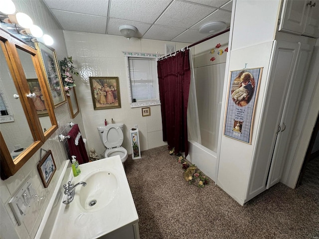 full bathroom with a paneled ceiling, vanity, toilet, and shower / bathtub combination with curtain