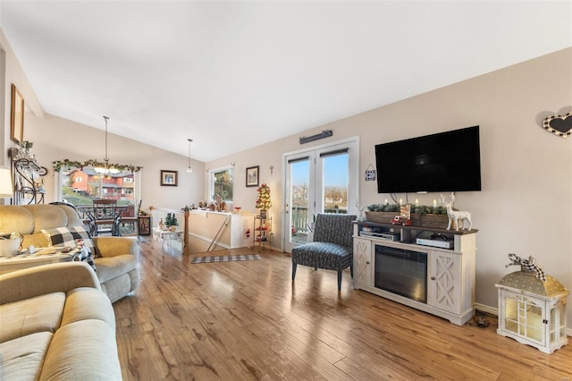 living room featuring french doors, hardwood / wood-style floors, and vaulted ceiling