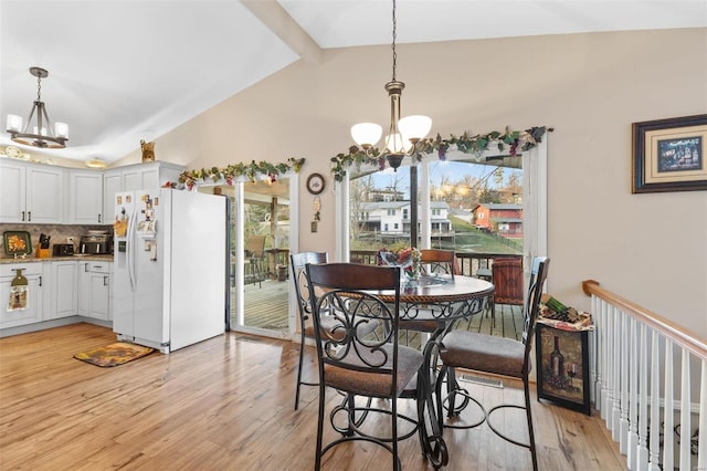 dining room featuring beamed ceiling, light wood-type flooring, high vaulted ceiling, and a chandelier