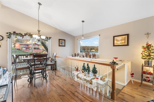 dining area with a notable chandelier, lofted ceiling, and hardwood / wood-style flooring